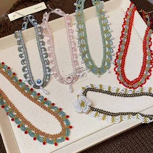 Macro view of colorful glass beaded lace necklaces with a vintage ethnic handmade design.