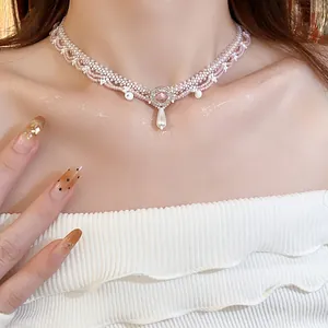 Close-up of a handmade pink beaded lace choker necklace with a pearl pendant detail.