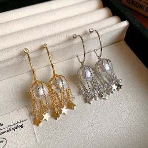 Détail de boucles d'oreilles créoles en C avec perles et franges étoilées élégantes