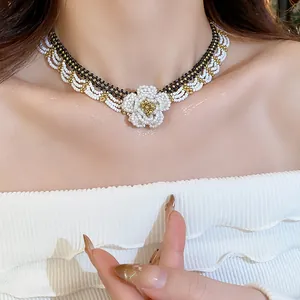 Detailed view of handmade white, black and gold glass beaded flower lace necklace