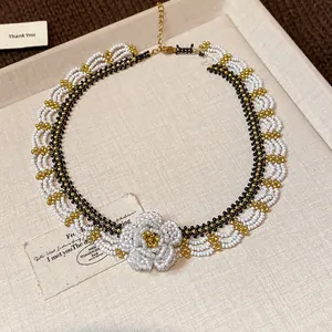 Macro detail of handmade glass beaded lace necklace with white camellia flower focal.