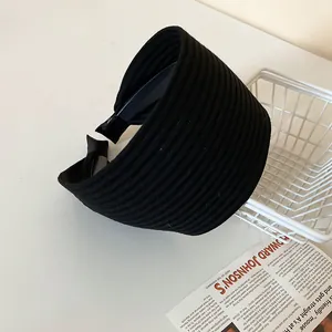 Close-up detail of a stylish wide black ribbed velvet headband for elegant hair styling
