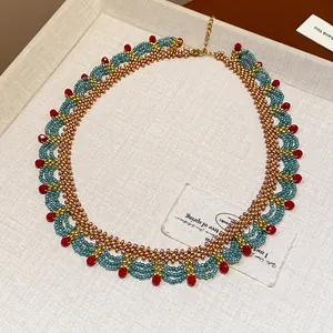 Macro view of handmade ethnic glass beaded necklace featuring elegant red crystal accents