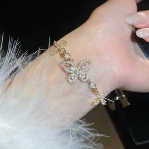 Close-up of elegant gold butterfly bracelet with shimmering zircon stones on a model wrist