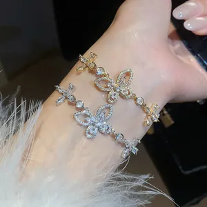 Close-up of elegant zircon butterfly bracelets in gold and silver finish worn on wrist