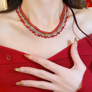 Detailed macro shot of an ethnic style red and silver beaded lace choker necklace on a model