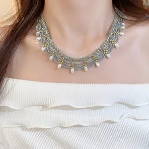 Elegant light blue glass beaded lace necklace with white drop pearls on model's neck