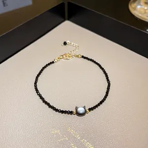 Close-up of black crystal beaded necklace featuring a minimalist cat head pendant design