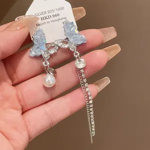 Close-up detail of silver needle butterfly tassel earring with crystal and pearl