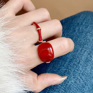 Dettaglio macro di un anello in smalto rosso con design in bambù placcato oro 18k