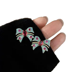 Elegantes pendientes de lazo vintage con detalles turquesas y circonitas rojas en tela