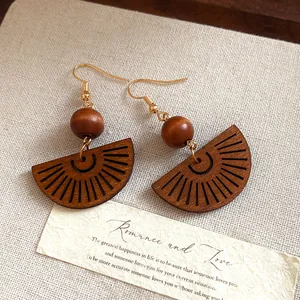 Detailed close-up showing the hollow fan-shaped design and wooden beads of these boho earrings