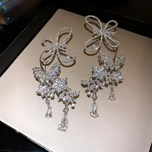 Detailed close-up view of luxurious rhinestone butterfly ear cuffs with elegant teardrop dangles