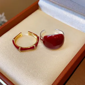 Dettaglio di due anelli in smalto rosso, stile bambù e cupola, in una confezione regalo