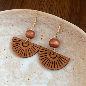 Detail of bohemian wood bead earrings with hollow fan-shaped pendant design