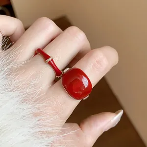 Elegante set di anelli in smalto rosso placcati oro 18k su una mano femminile curata