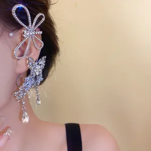Detailed shot of a silver butterfly ear cuff with sparkling rhinestones and dangling drops