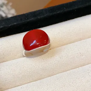 Primo piano di un anello regolabile in argento con smalto rosso a cupola minimalista