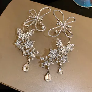 Intricate close-up of luxurious rhinestone butterfly ear cuffs with teardrop crystal charms