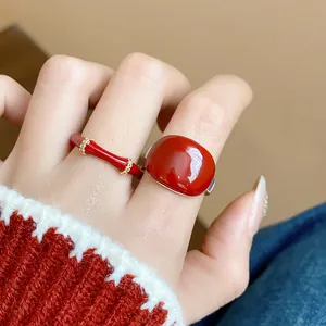 Primo piano dettagliato che mostra eleganti anelli aperti in smalto rosso placcati oro 18k