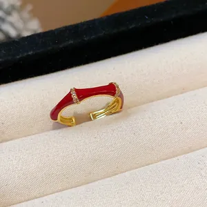 Dettaglio macro di un anello aperto in smalto rosso stile bambù con zirconi lucidi