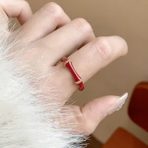 Vista dettagliata di un elegante anello in smalto rosso stile bambù placcato oro 18k zirconi