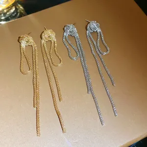 Close-up of retro gold and silver knotted chain tassel drop earrings with mesh texture