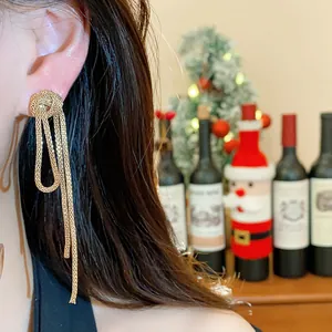 Detailed view of elegant gold knotted chain tassel earrings worn on a model's ear