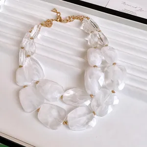 Detailed close-up of double-layer necklace with irregular white marbled acrylic beads