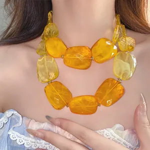Close-up detail of a double-layered necklace featuring chunky amber acrylic beads for a summer vibe