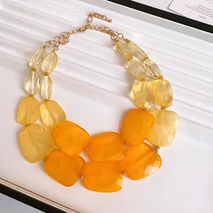 Close-up of double-layer necklace with vibrant orange and yellow irregular acrylic beads