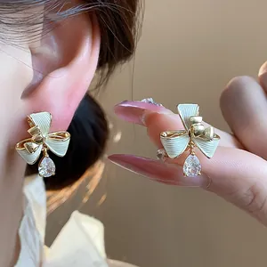 Primo piano dettagliato di orecchini a fiocco placcati in oro 18k con zirconi a goccia