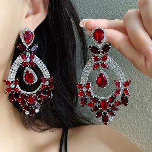 Macro view of ornate red crystal drop earrings featuring a vintage palace style design.