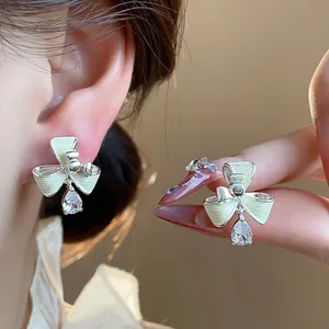 Dettaglio ravvicinato di orecchini a clip fiore in oro 18k con gocce di zircone