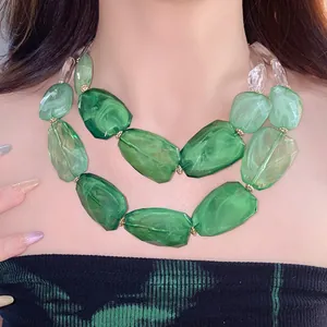 Close-up of green marbled acrylic beaded double-layer necklace on a model's neck.