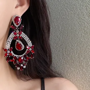 Macro view of luxurious red teardrop crystal earrings with sparkling white diamonds detail