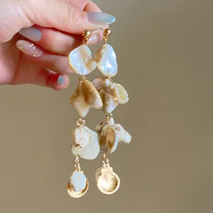 Detailed view of long irregular shell pearl dangle earrings for summer vacation style