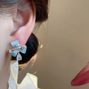 Primo piano di clip per orecchio a fiore in smalto blu con goccia di zircone lucido