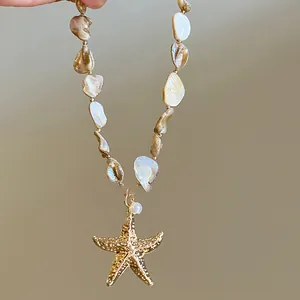 Close-up detail of a handmade irregular shell pearl necklace with a golden starfish pendant