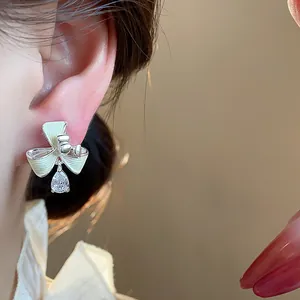 Primo piano di orecchini a clip a fiore placcati oro 18 carati con goccia di zircone
