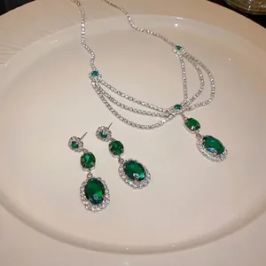 Elegant retro emerald and diamond jewelry set featuring necklace and dangle earrings