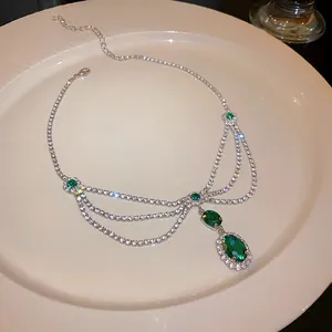 Elegant vintage court style necklace with green emerald stones and crystal tassels.