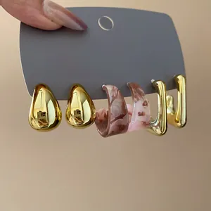 Elegante set van 3 paar geometrische oorbellen met goudkleurig metaal en marmerhars.