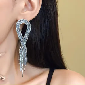 Elegant long tassel earrings encrusted with sparkling zircons shown on a model