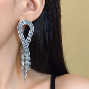 Close-up of elegant long geometric tassel earrings with sparkling zircons.
