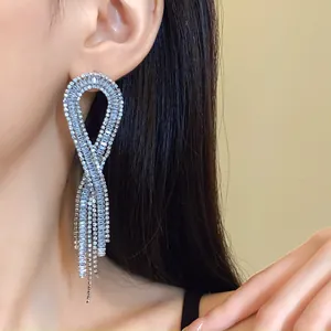 Close-up detail of silver zircon geometric tassel earrings worn elegantly on a model