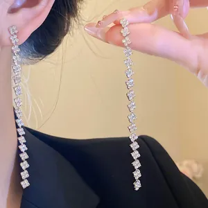 Detailed view of elegant silver-colored tassel earrings with shimmering square rhinestones