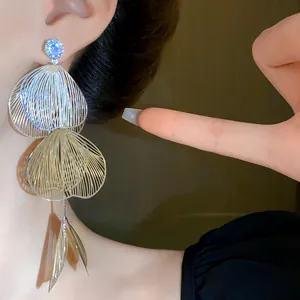 Detailed view of exaggerated floral tassel earrings with silver needle and rhinestones