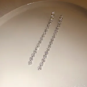 Detail view of sparkling square-cut cubic zirconia long tassel earrings