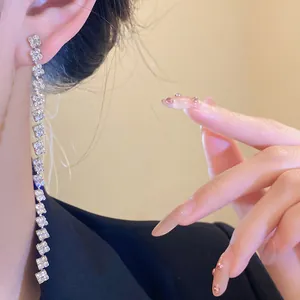 Close-up view of elegant silver tassel earrings featuring sparkling square rhinestones